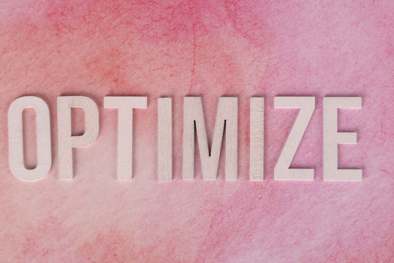 creative Creative display of the word OPTIMIZE on a pink textured surface.