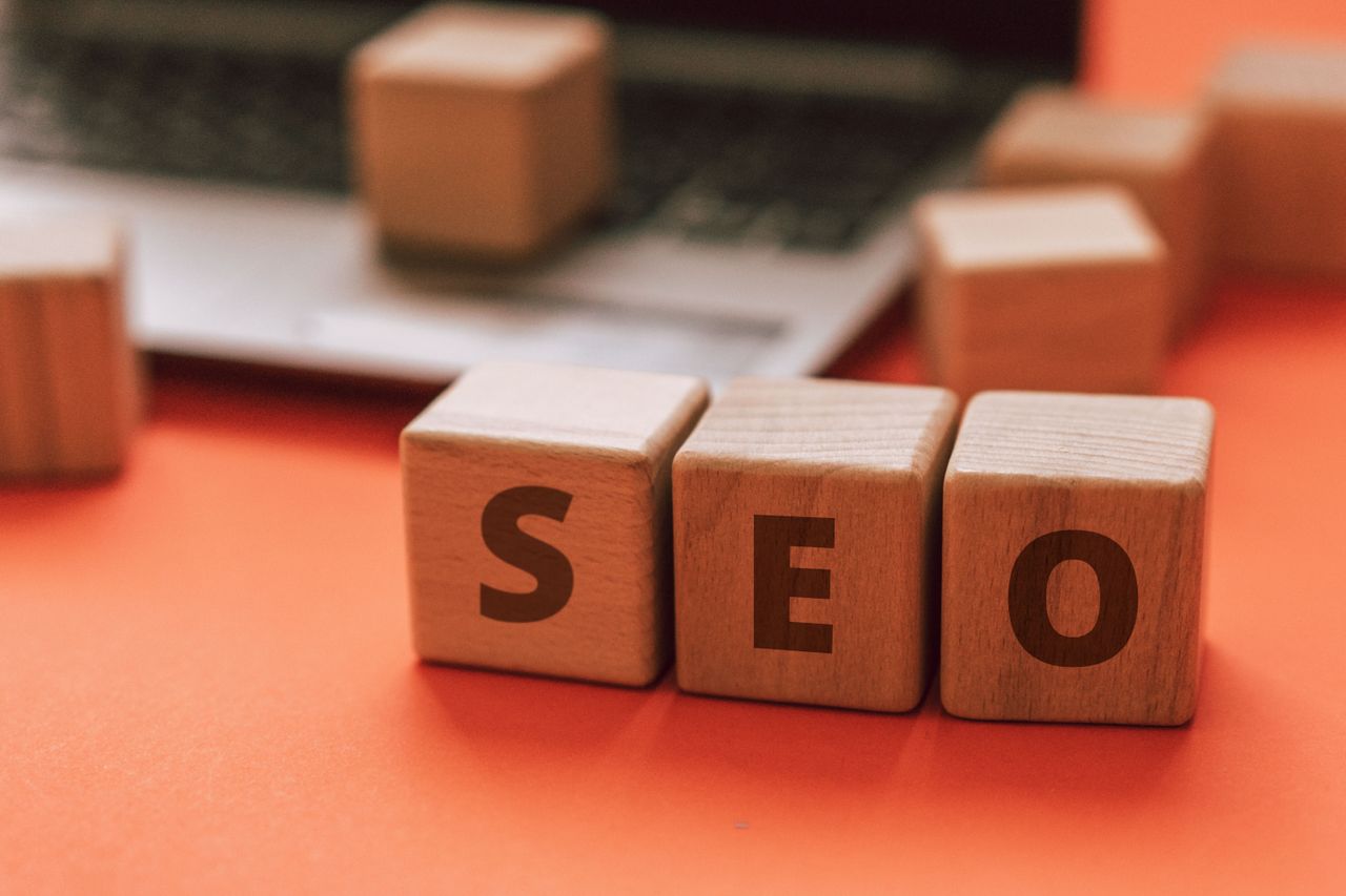 mobile-01 Wooden blocks spelling SEO on a laptop keyboard convey digital marketing concepts.