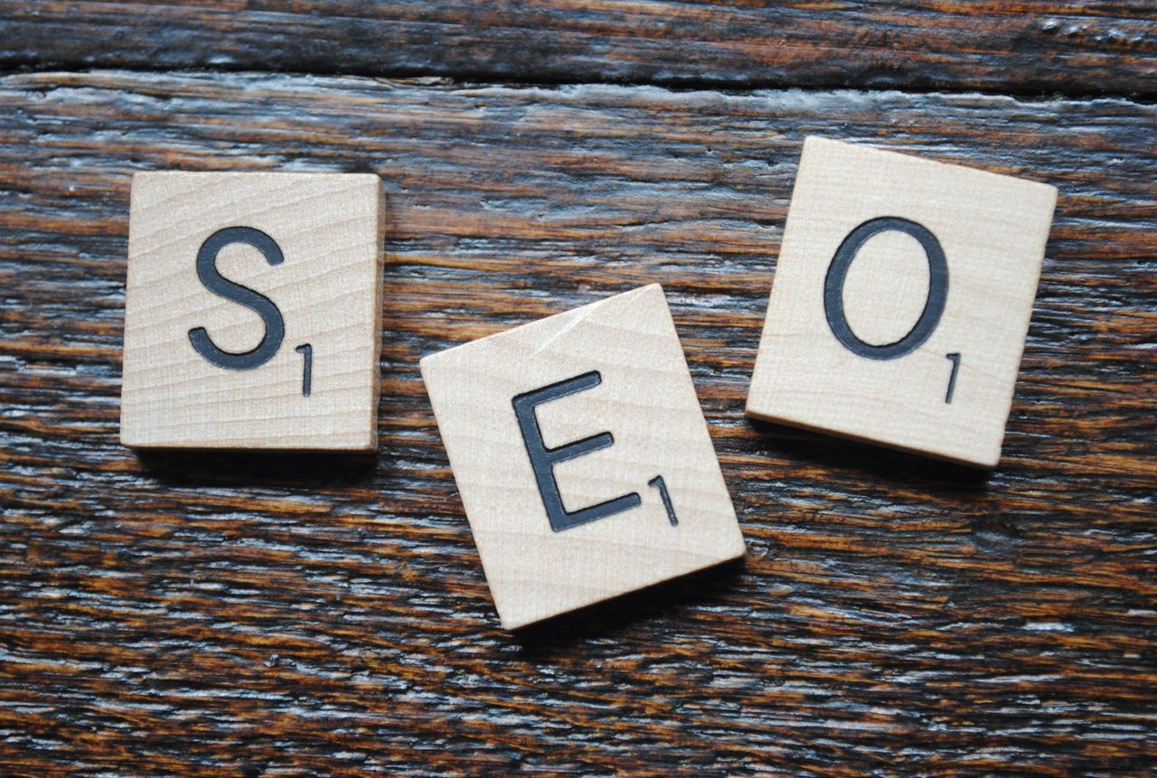 Services-03 Close-up of Scrabble tiles spelling SEO on a wooden table for content strategy.